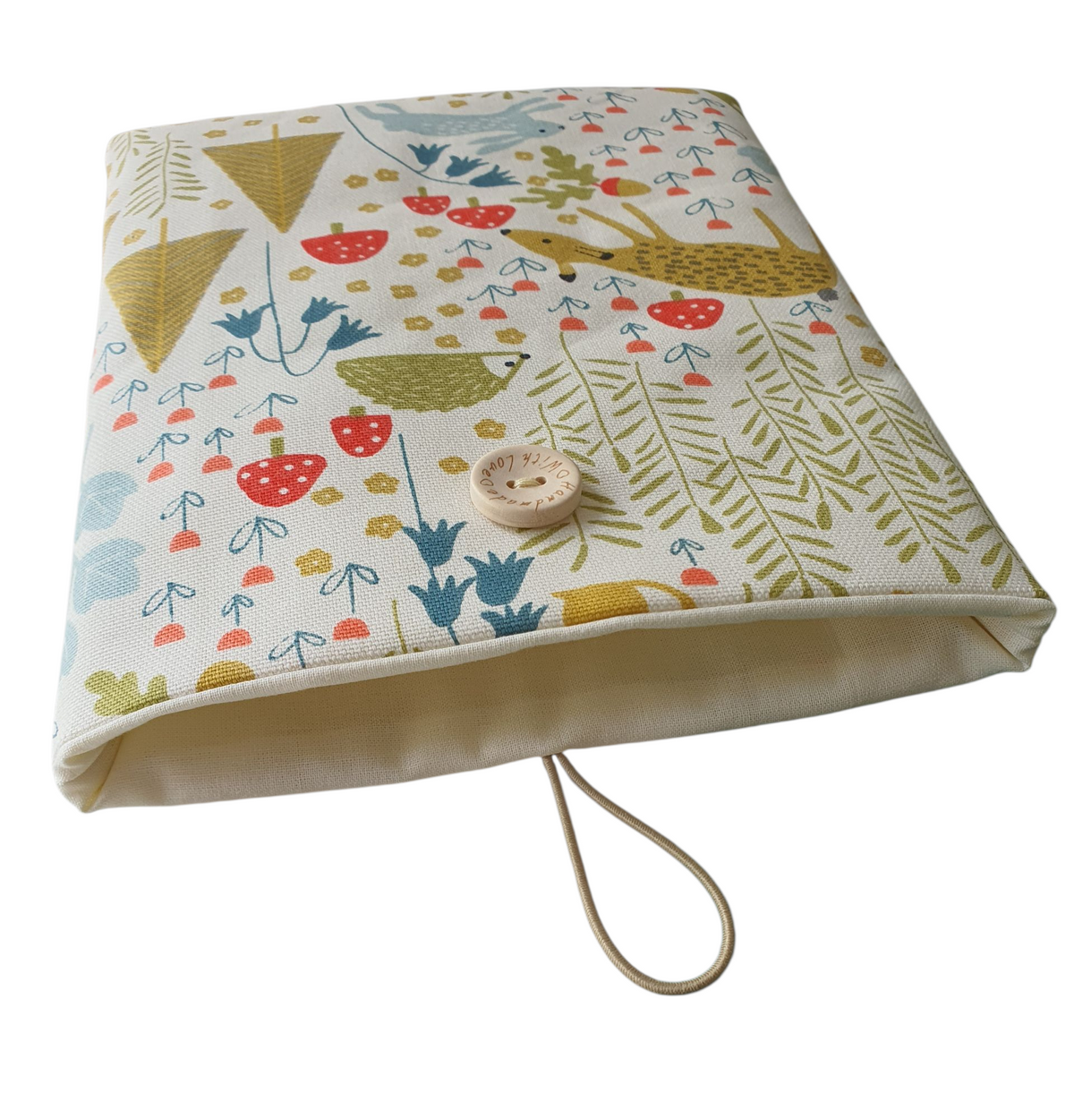 The forest animals patterned padded Book Pouch is lined with neutral fabric and fastens with elastic and a button.