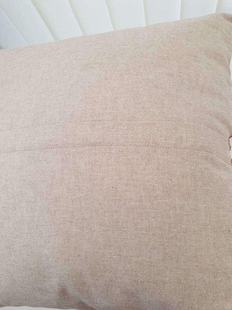 The rear of the cushion cover showing the neutral fabric on the reverse and the location of the zip, which is half way down in the reverse of the cushion cover.