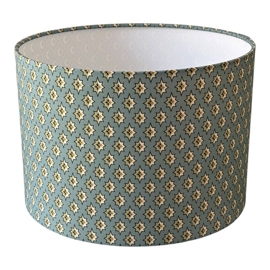 Selsey China Blue drum lampshade with small star-like shapes on blue fabric.