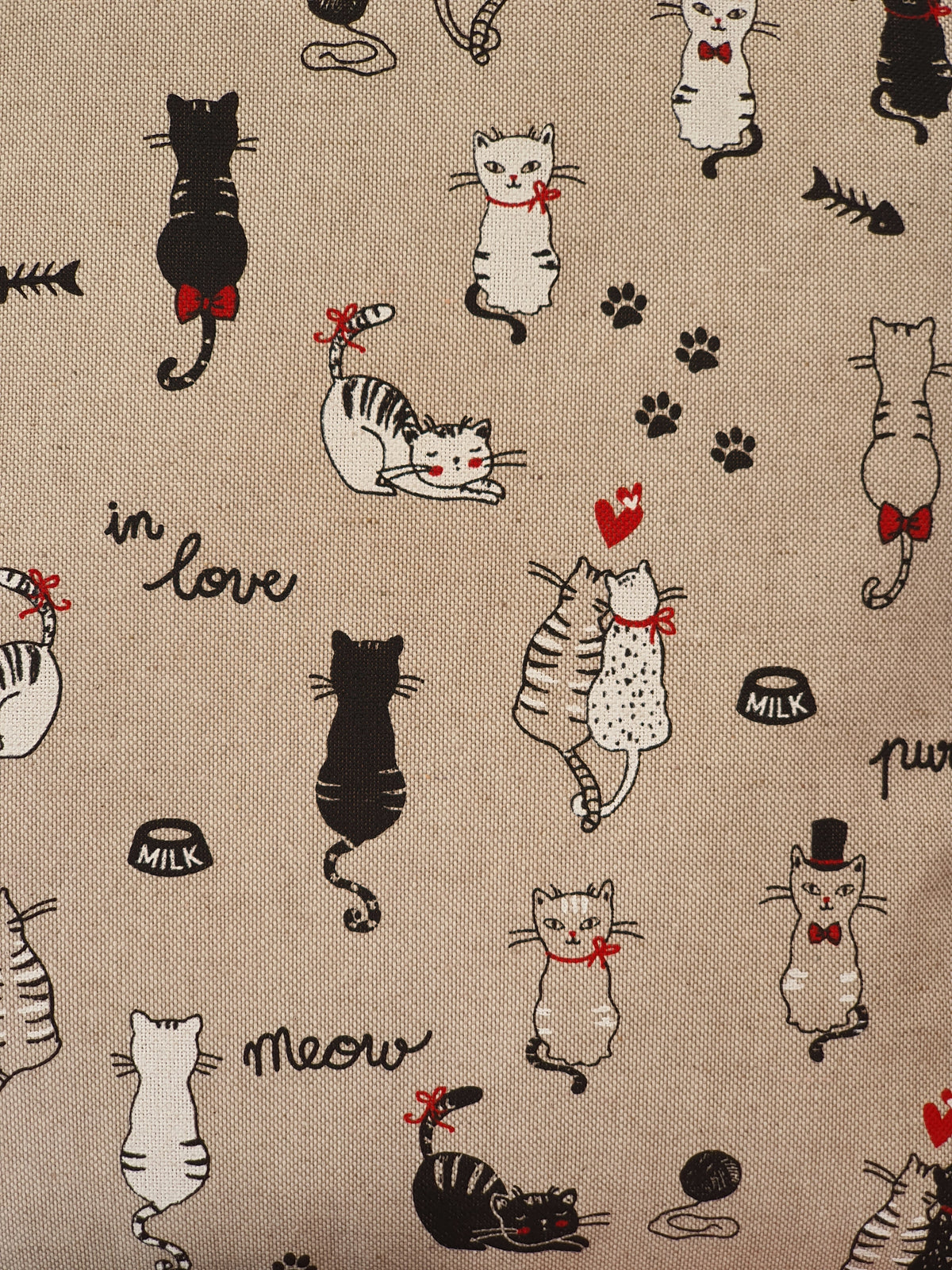 Close of up of the 'in love' cat pattern fabric.  The black and white cats, paws and hearts pattern is on a neutral background linen look fabric.
