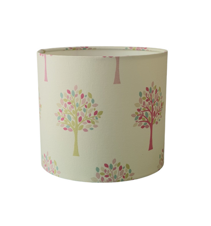 Two of the different coloured trees with their pastel leaves are shown on the lampshade fabric in this photo.  The drum lampshade is 20cms diameter and 18cms in height.