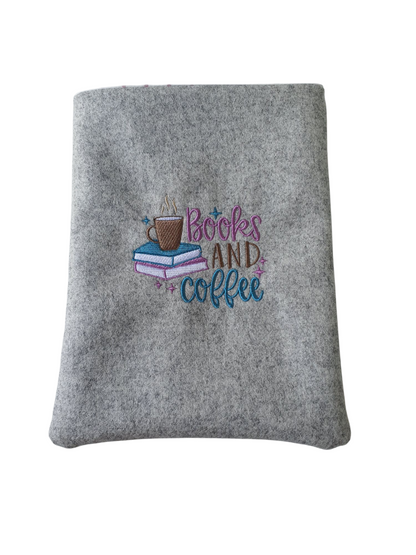 Handmade padded Book Pouch made with light grey boiled wool and machine embroidered with the pattern of 'Books and Coffee' which includes a coffee cup and two books.