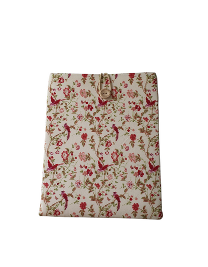 A front photo of the handmade padded Book Sleeve.  The floral and cranberry coloured hummingbird pattern is on a light coloured background.  The Book Cover fastens with an elastic loop and button.