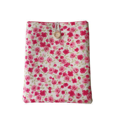 Handmade padded Book Pouch, Kindle Pouch, made with floral fabric, padded with fusible wadding and lined with complementing pink fabric.  The handmade Book Sleeve is approximately 8 inches by 6.5 inches (20cms x 17cms) and fastens with elastic and a button.