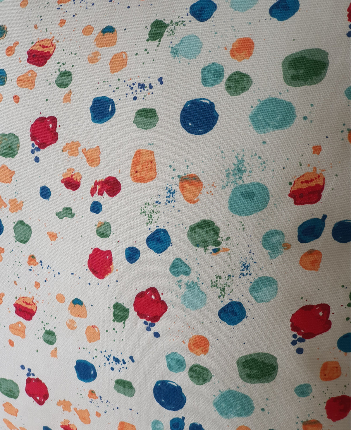 Close up of the multicolour Splat Paintbox fabric pattern.  The colours include red, shades of blue, green and peachy orange colours.