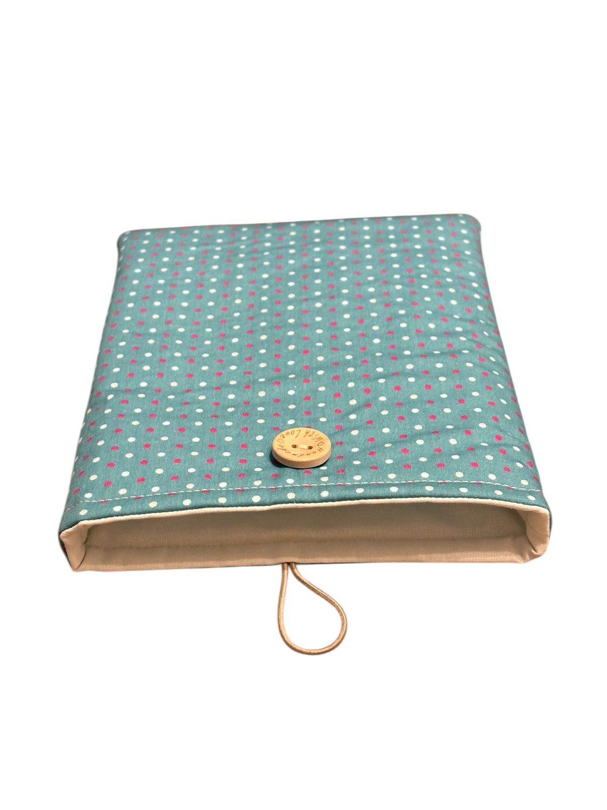 The handmade padded Book Cover is lined with neutral fabric, padded with fusible fleece and has elastic and button fastening.