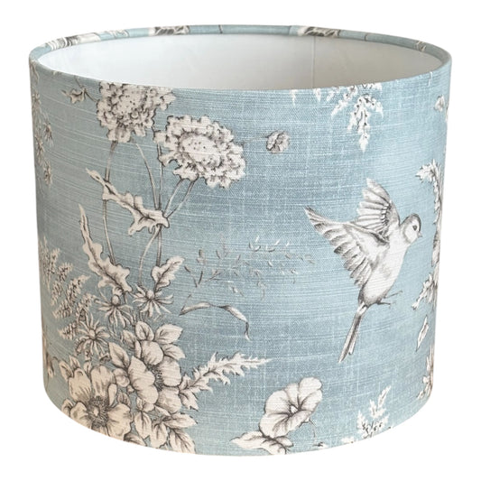 Blue Finch Toile drum lampshade with pale birds and flowers on blue fabric.