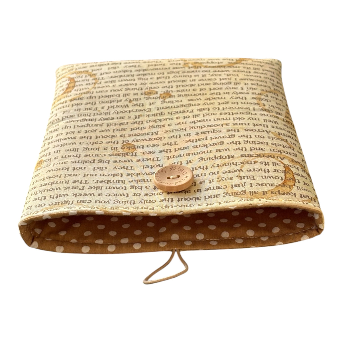 The Book Pouch has been padded with fusible fleece and will protect books from wear and tear whilst being carried on the go.  The complementing polka dot fabric lining the Book Cover is shown in this photo, along with the wooden button and elastic closure.