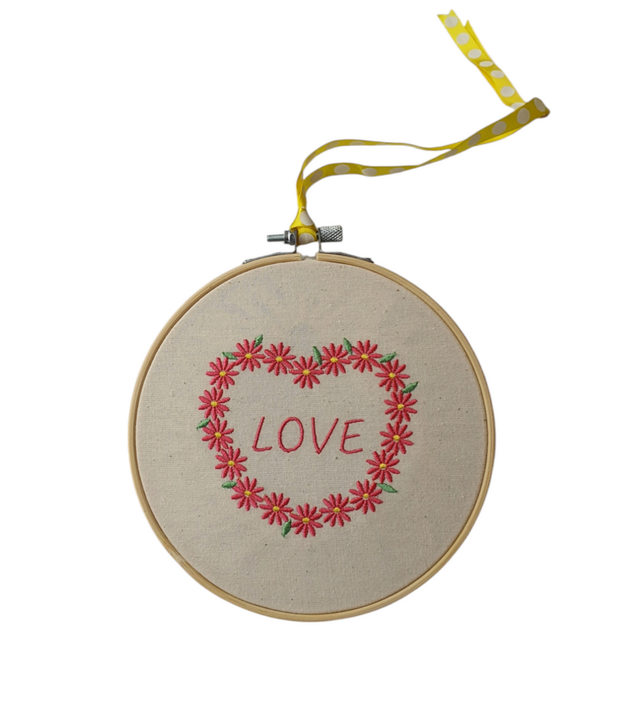 Embroidered floral heart displayed in a bamboo hoop