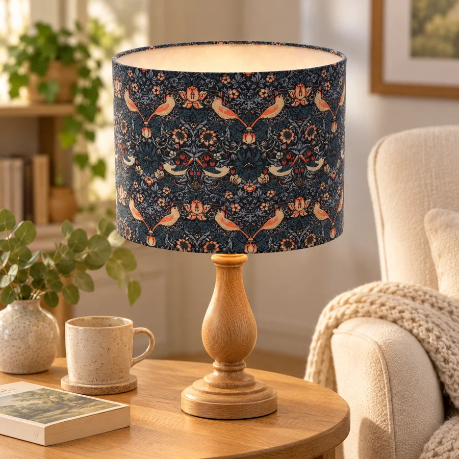 Blue Strawberry Thief drum lampshade styled on a wooden lamp base